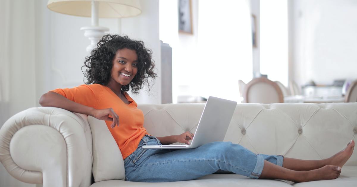 Woman sitting on a couch with a laptop