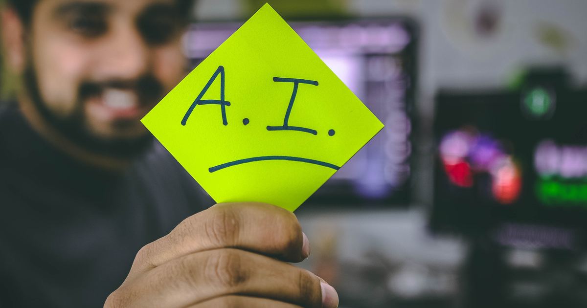 Writer holding sticky note that says AI