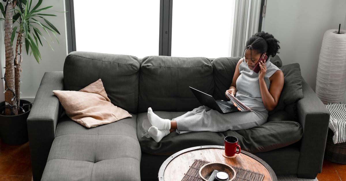 Writer sitting on couch with laptop