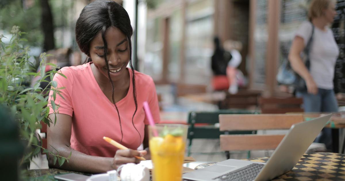 Writer sitting outside at a table with laptop