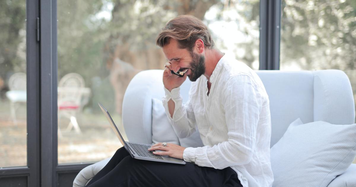 Writer smiling while working on laptop