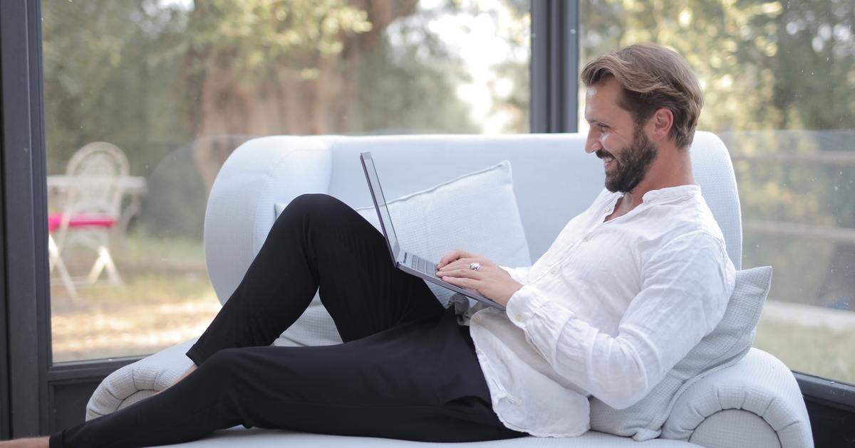 Writer laying on couch with laptop