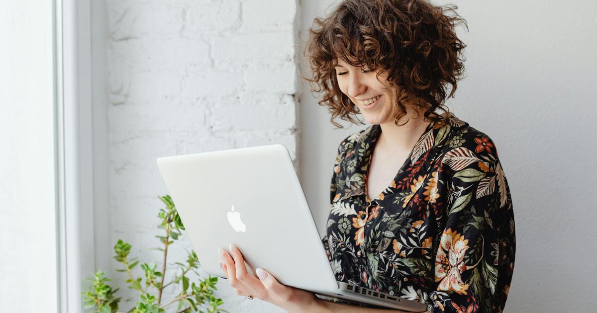 Writer smiling typing on a laptop