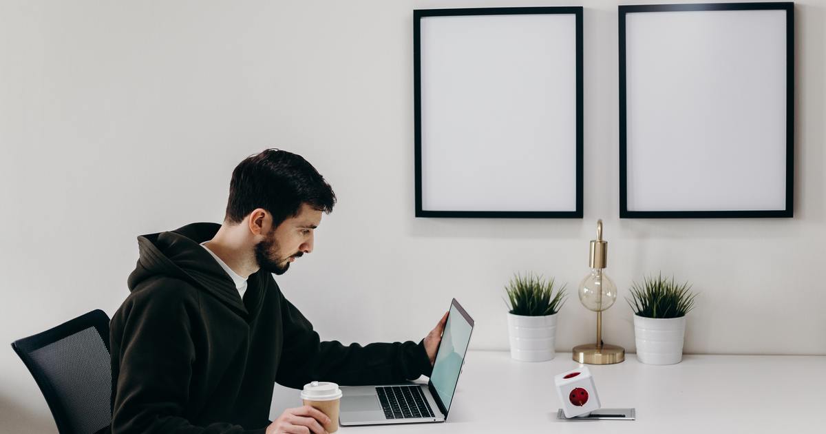 Writer sitting at a table with laptop and coffee