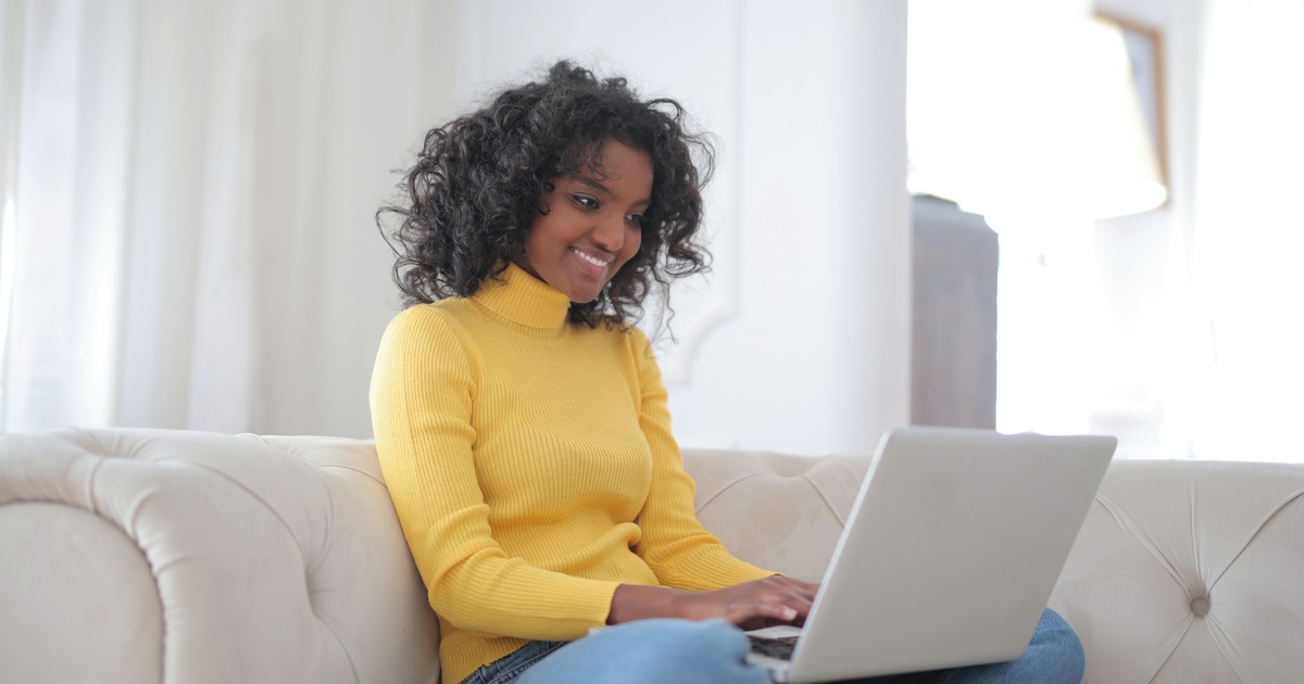 Writer sitting on couch with laptop