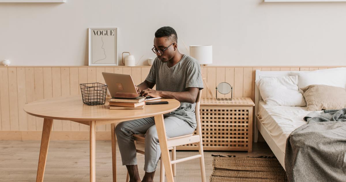 Writer sitting at a table typing on a laptop