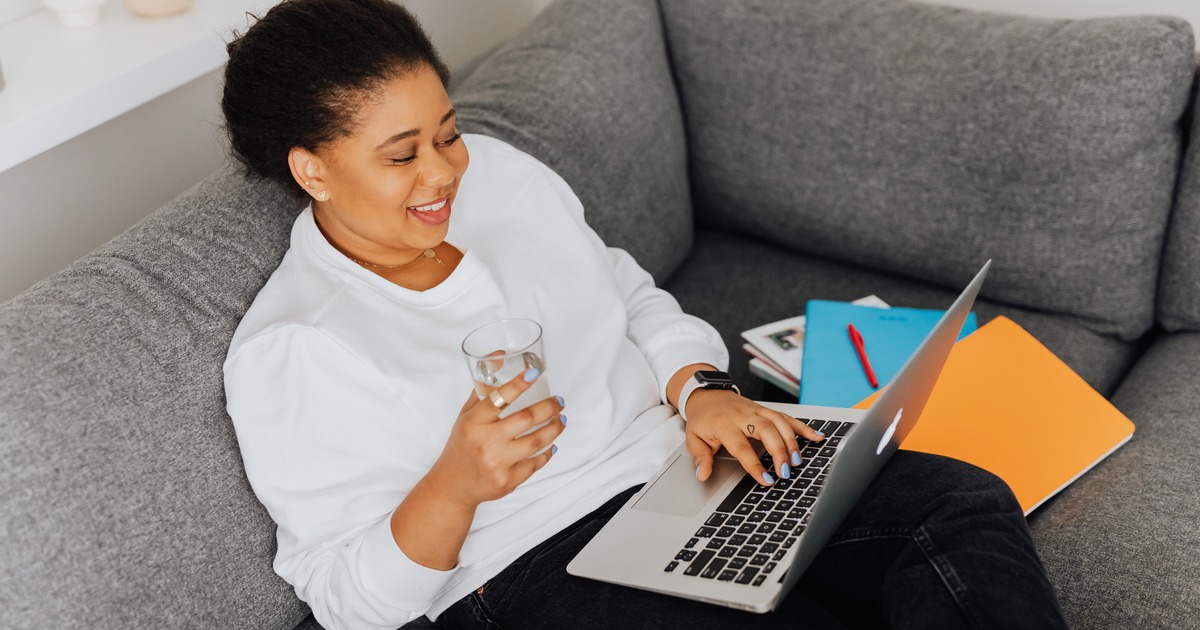 Writer smiling while looking at laptop