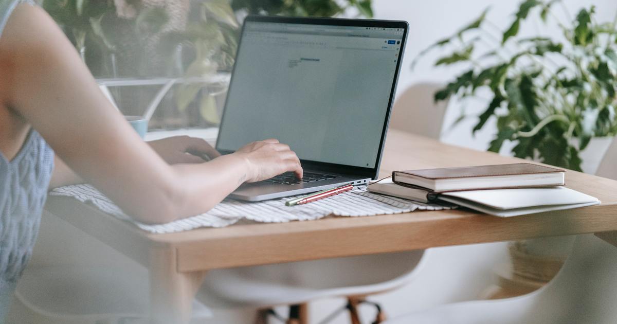 Writer typing on laptop at table