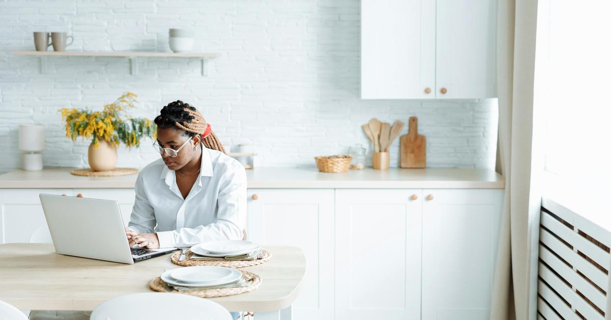 Writer sitting with laptop at kitchen table